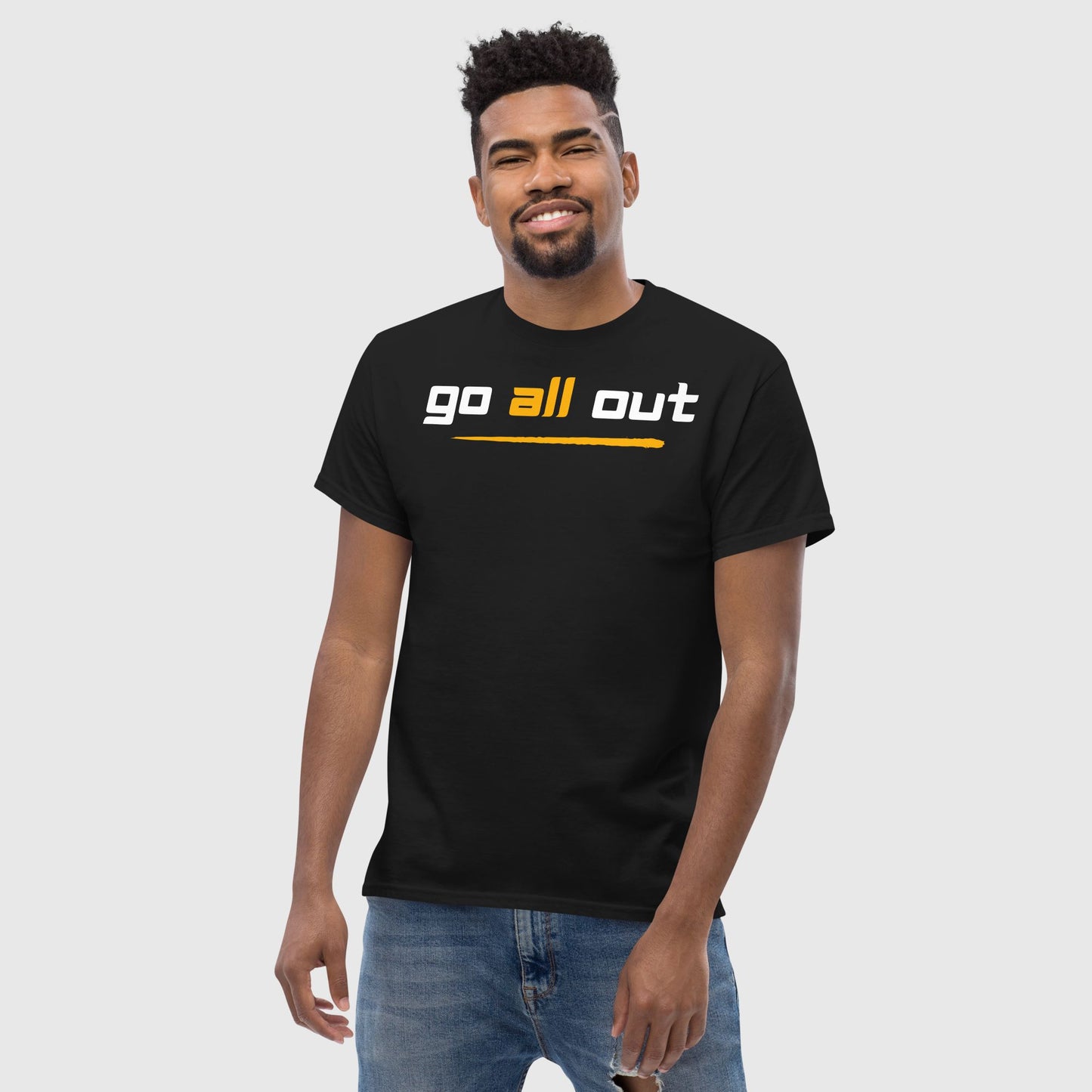 Man wearing a black t shirt with a chest print 'go all out' 