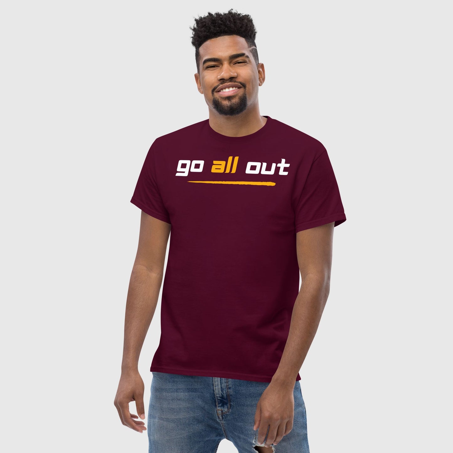 Man smiling wearing 'go all out'printed maroon t shirt