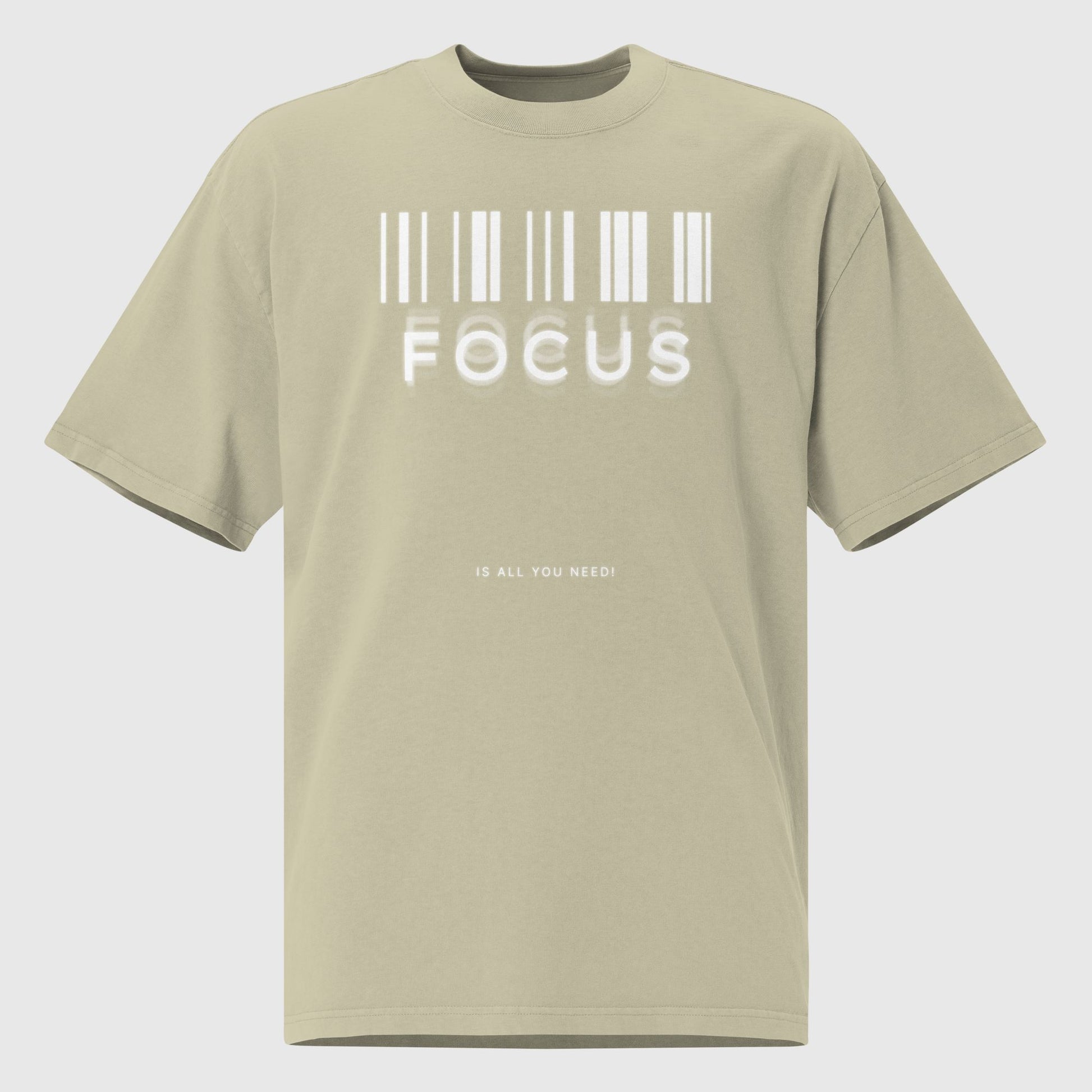 flat lay of a printed graphic oversized shirt in faded eucalyptus colour with print saying, "focus is all you need"