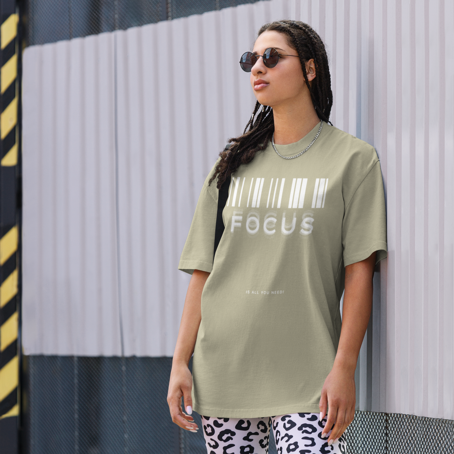 woman on street printed graphic oversized shirt in faded eucalyptus colour with print saying, "focus is all you need"