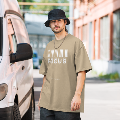 man on street in printed graphic oversized shirt in faded khaki colour with print saying, "focus is all you need"