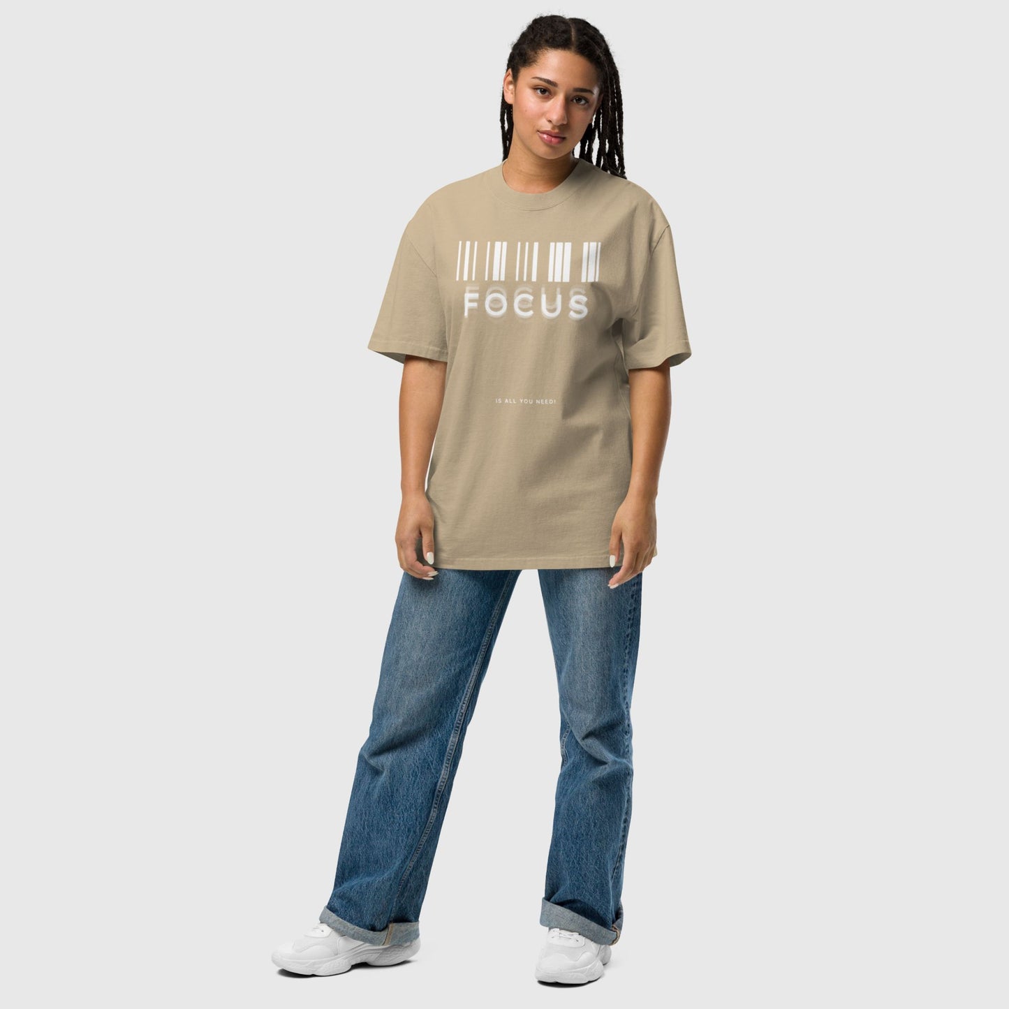 woman wearing printed graphic oversized shirt in faded khaki colour with print saying, "focus is all you need"