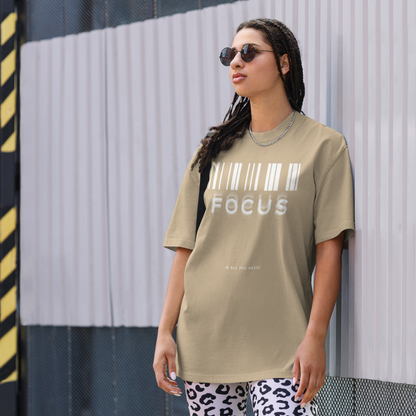 woman on street in printed graphic oversized shirt in faded khaki colour with print saying, "focus is all you need"