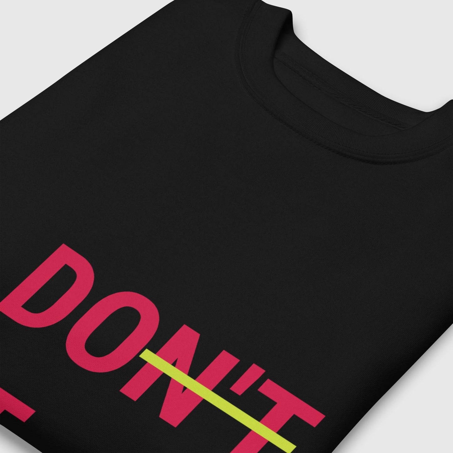 a folded black don't quit, do it sweatshirt from side up angle